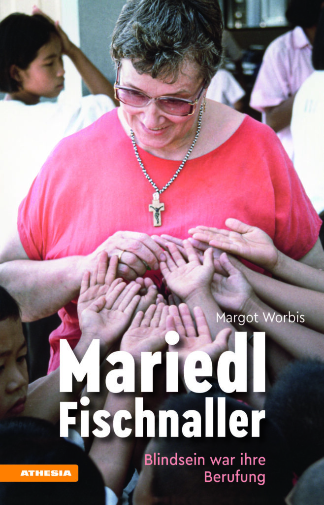 Eine Person in einem roten Shirt wird umgeben von mehreren ausgestreckten Kinderhänden.